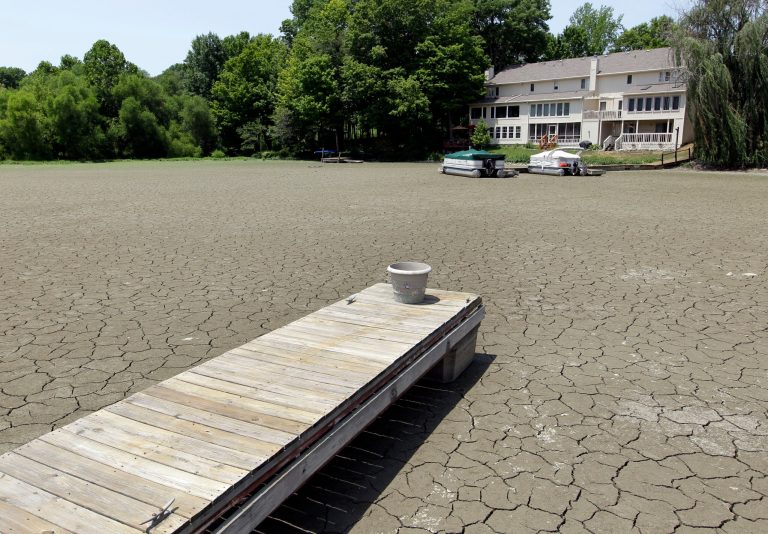   FILE - In this July 5, 2012 file photo, a dock extends into a dry cove at Morse Reservoir in Noblesville, Ind., as oppressive heat and drought conditions stifle the middle of the United States. In 2012 many of the warnings scientists have made about global warming went from dry studies in scientific journals to real-life experience. One example: July was the hottest month in record-keeping U.S. history. (AP Photo/Michael Conroy, File)  