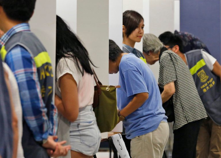 People vote in a polling station for an unofficial referendum on democratic reform in Hong Kong Sunday, June 22, 2014. More than half a million Hong Kongers have voted in an unofficial referendum on democratic reform in the specially administered Chinese city that Beijing has blasted as illegal.  (AP Photo/Kin Cheung)