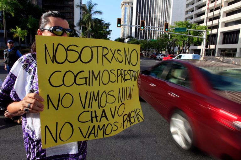 A protestor holds a sign that reads: 