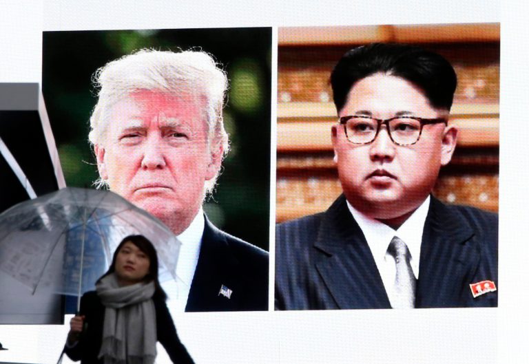 A woman walks by a huge screen showing U.S. President Donald Trump, left, and North Korea's leader Kim Jong Un, in Tokyo, Friday, March 9, 2018. After a year of threats and diatribes, U.S. President Donald Trump and third-generation North Korean dictator Kim Jong Un have agreed to meet face-to-face for talks about the North's nuclear program.(AP Photo/Koji Sasahara)