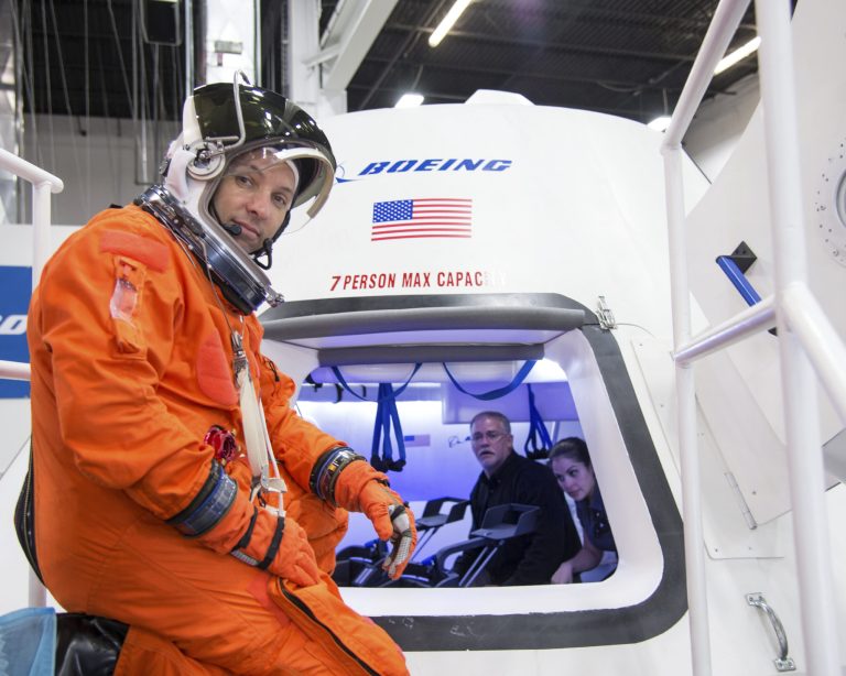 In this undated image provided by NASA, astronaut Randy Bresnik prepares to enter The Boeing Company's CST-100 spacecraft for a fit check evaluation at the company's Houston Product Support Center. On Tuesday, Sept. 16, 2014, NASA will announce which one or two private companies wins the right to transport astronauts to the International Space Station. The deal will end NASA's expensive reliance on Russian crew transport. The contenders include SpaceX, Sierra Nevada Corp., and Boeing. (AP Photo/NASA)