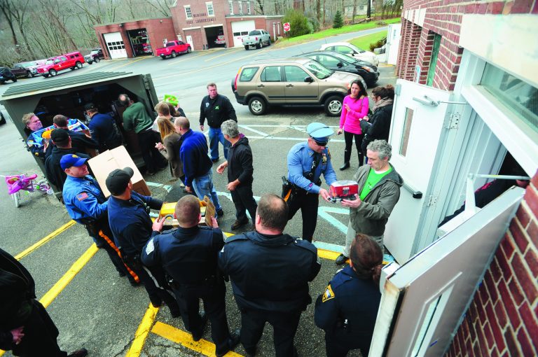 Closter Police and 28 other police departments, including the Bergen County Sheriff's Department, deliver a truck full of toys for Newtown families, on Friday, Dec. 21, 2012, in Newtown, Conn. (AP Photo/The Record of Bergen County, Marko Georgiev) ONLINE OUT; MAGS OUT; TV OUT; INTERNET OUT; NO ARCHIVING; MANDATORY CREDIT