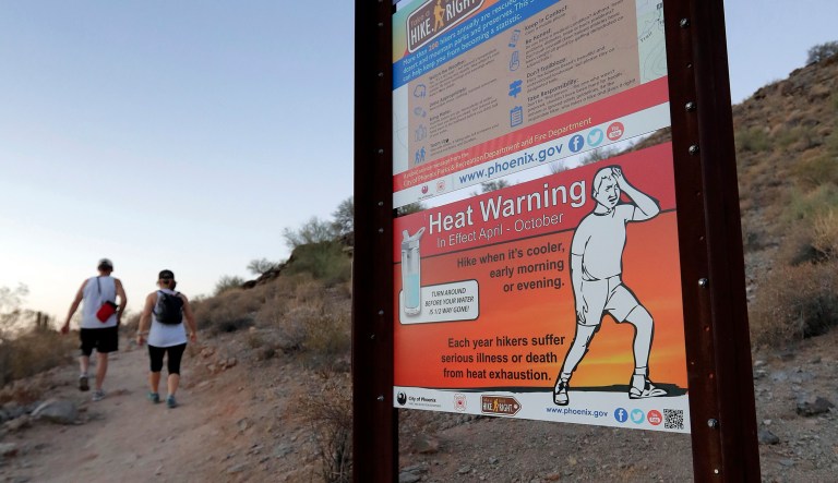 A sign warns hikers about severe heat as they begin their hike at sunrise to avoid the excessive heat, Friday, June 16, 2017, in Phoenix. NASA said 2017 was the second warmest ever by global average surface temperature, ranking only behind 2016. (AP Photo/Matt York)