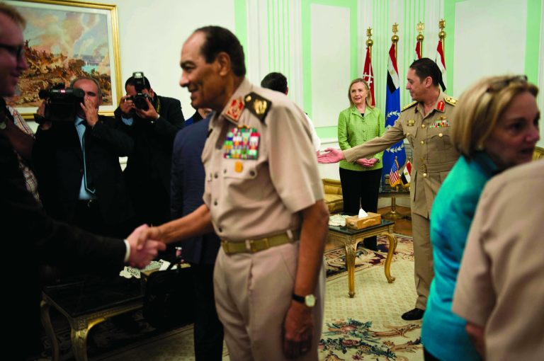 US Secretary of State Hillary Rodham Clinton, back center, watches as Field Marshal Hussein Tantawi, second left, greets members of the American delegation before a meeting at the Ministry of Defense July 15, 2012 in Cairo, Egypt. Clinton is holding talks with Egypt's top military leaders to press for the military to work with Egypt's new Islamist leaders on a full transition to civilian rule. (AP Photo/Brendan Smialowski, Pool)