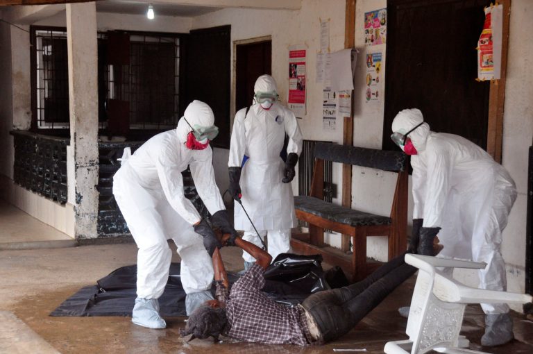 Health workers in protective gear move the  body of a person that they suspect dyed form the Ebola virus in Monrovia, Liberia, Tuesday, Sept. 16, 2014. The number of Ebola cases in West Africa could start doubling every three weeks and it could end up costing nearly $1 billion to contain the crisis, the World Health Organization warned Tuesday.  (AP Photo/Abbas Dulleh)