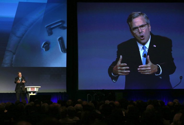 Former Florida governor Jeb Bush is seen on a video monitor as he speaks during the 2015 National Auto Dealers Association conference on January 23, 2015 in San Francisco. (Photo by Justin Sullivan/Getty images)