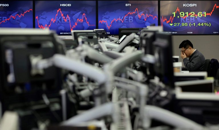 FILE - In this Monday, Jan. 27, 2014, file photo, a currency trader adjusts his glasses near the screens showing the Korea Composite Stock Price Index (KOSPI) at the foreign exchange dealing room of the Korea Exchange Bank headquarters in Seoul, South Korea.  A global sell-off in stocks this year has left many small investors more puzzled than panicked and unsure how to act. Ordinary investors around the world were on edge even before signs of a slowdown in China and plunging emerging-market currencies sent stocks tumbling earlier this past week.  Stocks had soared by double-digit percentages in countries like the United States, Japan and France in 2013, raising fears that they had climbed too fast and were due to drop.(AP Photo/Lee Jin-man, File)