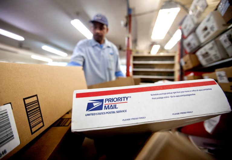 FILE - This Feb. 7, 2013 file photo shows packages waiting to be sorted in a Post Office in Atlanta. Regulators on Tuesday, Dec. 24, 2013, approved a price hike of 3 cents for a first-class stamp, bringing the charge to 49 cents a letter in an effort to help the Postal Service recover from severe mail decreases brought on after the 2008 economic downturn.(AP Photo/David Goldman, File)