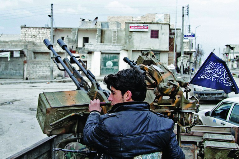 In this Friday February 8, 2013, photo, a Free Syrian Army fighter sits behind an anti-aircraft weapon in Aleppo, Syria. Syrian rebels brought their fight within a mile of the heart of Damascus on Friday, seizing army checkpoints and cutting a key highway with a row of burning tires as they pressed their campaign for the heavily guarded capital, considered the likely endgame in the nearly 2-year-old civil war. (AP Photo/Abdullah al-Yassin)