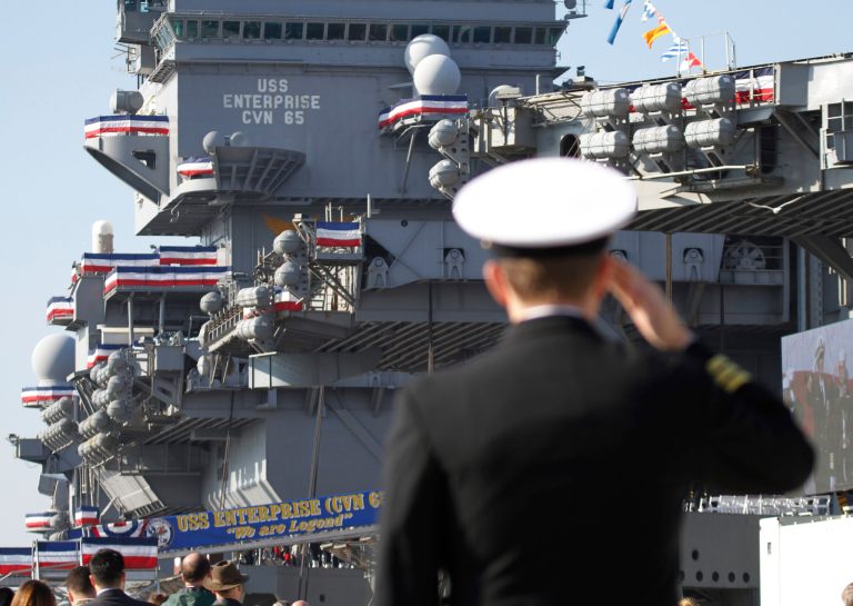 A Navy officer salutes during the inactivation ceremony for the aircraft carrier USS Enterprise in 2012. Syed Rizwan Farook served at various posts, including the USS Enterprise, in the Surface Warfare Officer School Unit in Great Lakes, Ill. (AP Photo/Steve Helber)