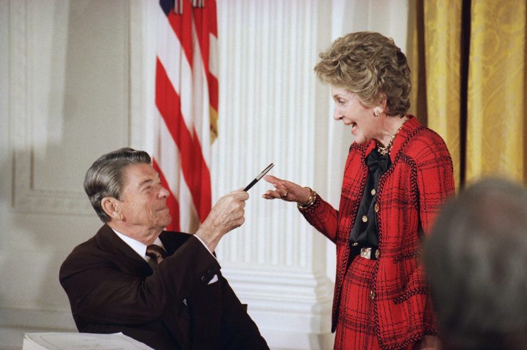 FILE - In this Nov. 18, 1988 file photo, former President Ronald Reagan hands a pen to then first lady Nancy Reagan after he signed a major anti-drug bill at a White House East Room ceremony in Washington. Reagan dedicated the bill to Nancy, who has led a 