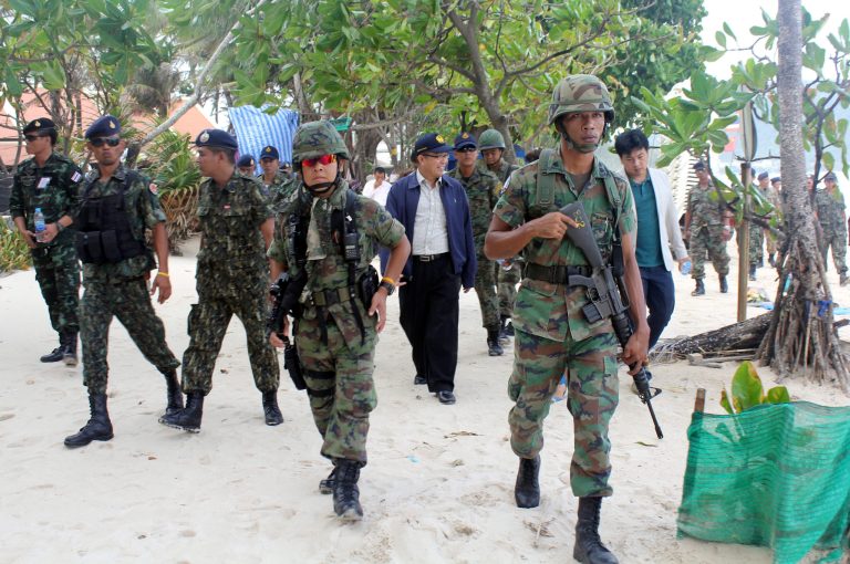Armed Thai soldiers and local officials inspect the Patong beach during a clean up operation Wednesday, July 9, 2014, in Phuket, southern Thailand. Thailand's new military junta sent soldiers to one of the country's best known beaches Wednesday to evict food hawkers, massage huts and other illegal vendors as part of a campaign to clean-up the country's image and enforce laws that have long been ignored. (AP Photo/Krissada Mueanhawong)