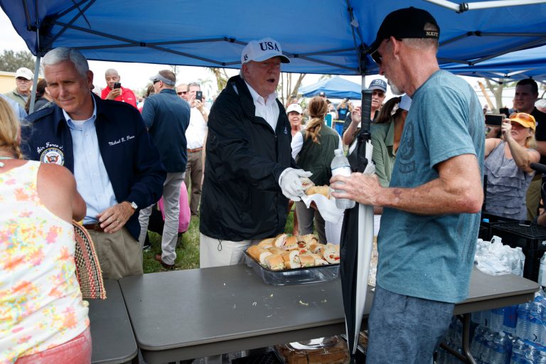 President Donald Trump, Vice President Mike Pence and first lady Melania Trump hand out food to people impacted by Hurricane Irma at Naples Estates, Thursday, Sept. 14, 2017, in Naples, Fla. (AP Photo/Evan Vucci)