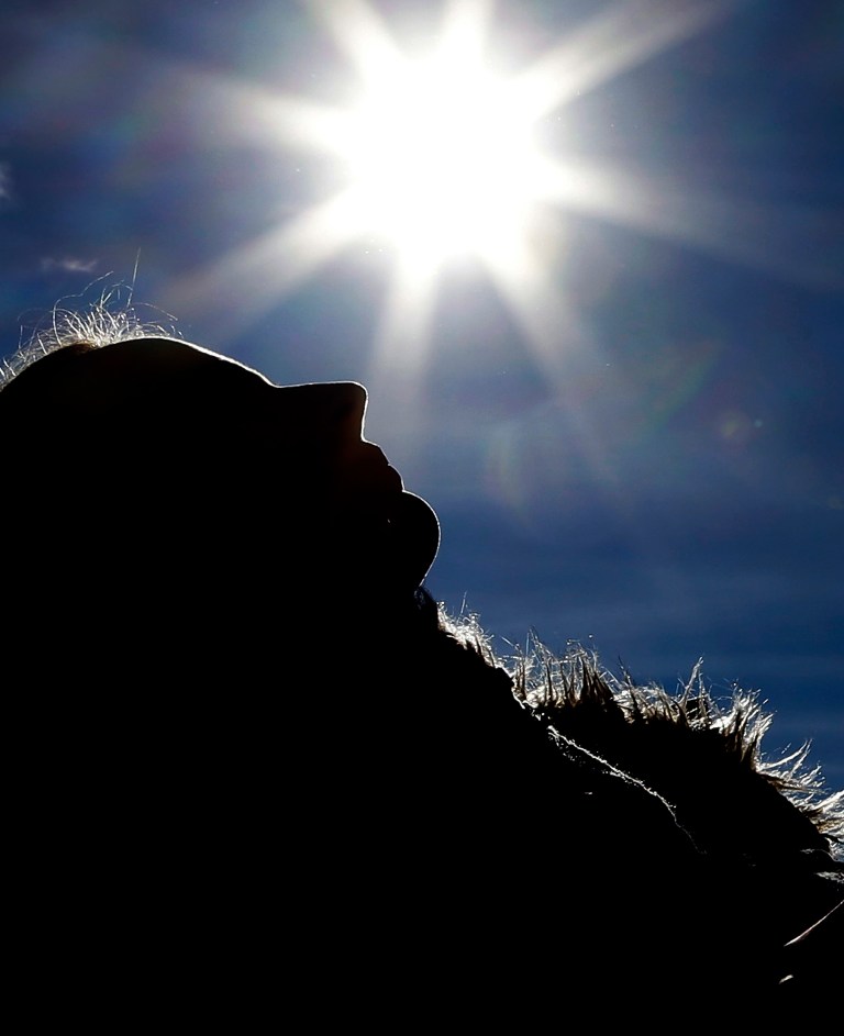 A woman lays in the sun outside the Swiss House at the 2014 Winter Olympics, Wednesday, Feb. 12, 2014, in Sochi, Russia. Temperatures are predicted near 60 degrees Fahrenheit in Sochi on Wednesday. (AP Photo/Morry Gash)