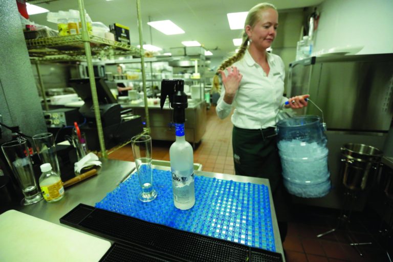 Manager Lindsay Pitts walks around the bar which is beyond the view of patrons in the kitchen of La Jolla Groves Restaurant Monday, Feb. 26, 2013, in Salt Lake City. Utah lawmakers are considering repealing a law that requires restaurants to mix alcoholic drinks out of view from patrons. Commonly known as 
