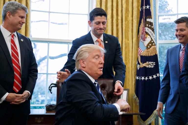Rep. Bill Huizenga, R-Mich., left, and Rep. Sean Duffy, R-Wis., right, watch as House Speaker Paul Ryan of Wis. pats President Donald Trump on the back after the president signed the House Joint Resolution 41, abolishing the Obama-era rule requiring the energy industry to report foreign dealings. (AP Photo/Evan Vucci)