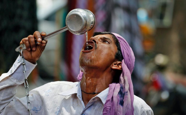 An Indian cycle rickshaw puller drinks water on a hot day in Allahabad, India, Saturday, June 7, 2014. Thousands of people enraged by power cuts during an extreme heat wave have been rioting across northern India, setting electricity substations on fire and taking power company officials hostage, officials said Saturday. (AP Photo/Rajesh Kumar Singh)