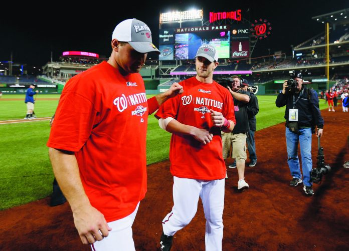 Rob Carr/Getty Images
Ryan Zimmerman, left, Bryce Harper and the Nats secured a playoff berth on Thursday night by beating the Dodgers.