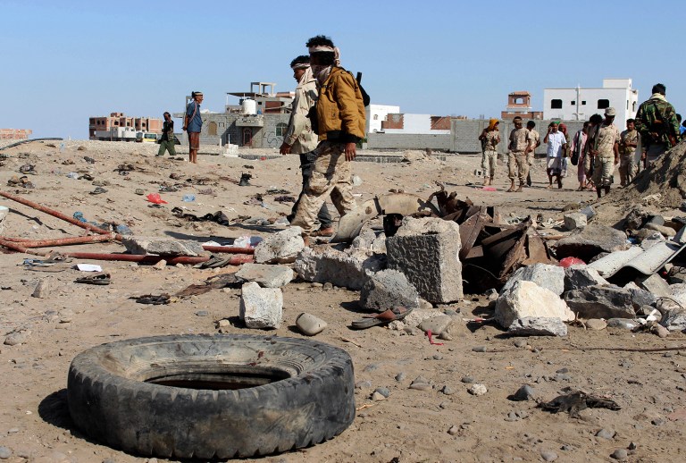 Soldiers gather the site of a suicide bomb at a base in the southern city of Aden, Yemen, Sunday, Dec. 18, 2016. (AP Photo/Wael Qubady)