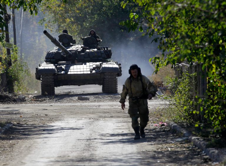 A pro-Russian rebel tank rolls to take position near to the airport in the town of Donetsk, eastern Ukraine, Friday, Oct. 3, 2014.  Artillery fire hit Donetsk airport Friday as Pro-Russian rebels are pressing to seize the key airport in eastern Ukraine despite fierce resistance from government forces.(AP Photo/Darko Vojinovic)