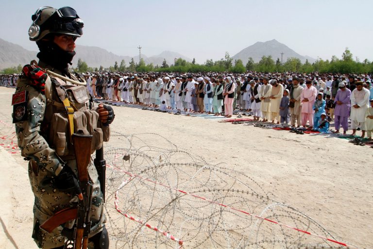 An Afghan soldier stands guard during Eid al-Fitr prayers in Kandahar, south of Kabul, Afghanistan, Monday, July 28, 2014. Eid al-Fitr prayer marks the end of the holy fasting month of Ramadan.(AP Photo/Allauddin Khan)