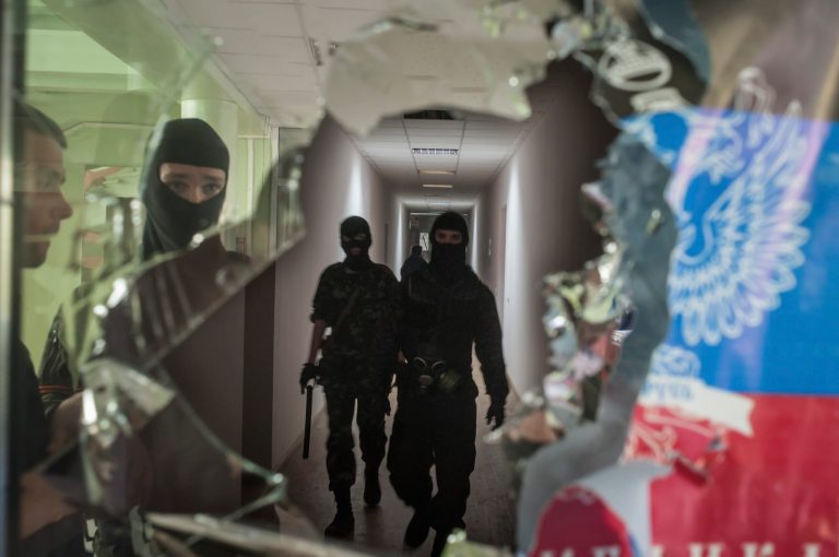 Masked pro-Russian militants patrol in the local administration building in Mariupol, Ukraine, Saturday, April 26, 2014. A pro-Russian insurgency leader in eastern Ukraine said Saturday that foreign military observers detained as suspected NATO spies could be released in exchange for jailed pro-Russian activists. (AP Photo/Evgeniy Maloletka)