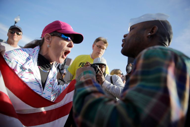 A pro-police protester, left, and counter protester yell at each other outside the Ferguson Police Department. [AP Photo