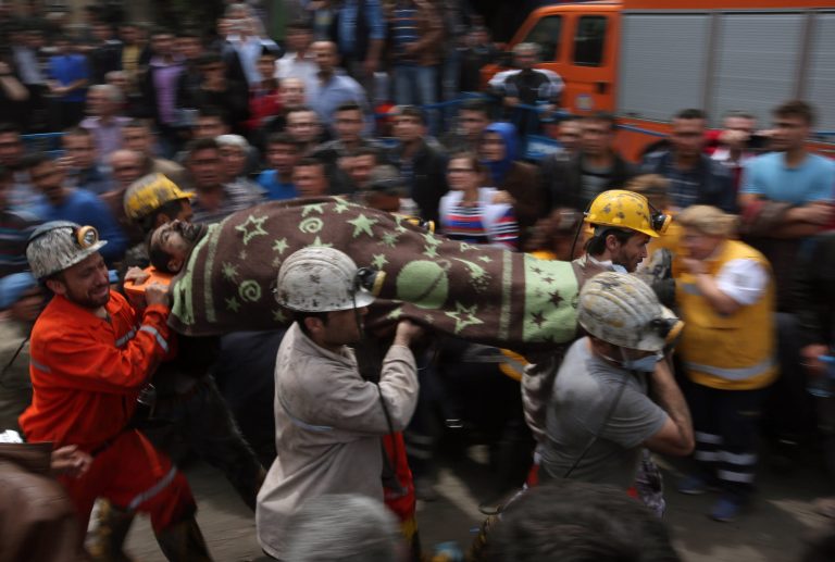 Rescue workers carry the dead body of a miner outside the coal mine in Soma, Turkey, Wednesday, May 14, 2014.  An explosion and fire at the coal mine killed at least 232 workers, authorities said, in one of the worst mining disasters in Turkish history. Turkey's Energy Minister Taner Yildiz said 787 people were inside the coal mine at the time of the accident. (AP Photo/Emrah Gurel)