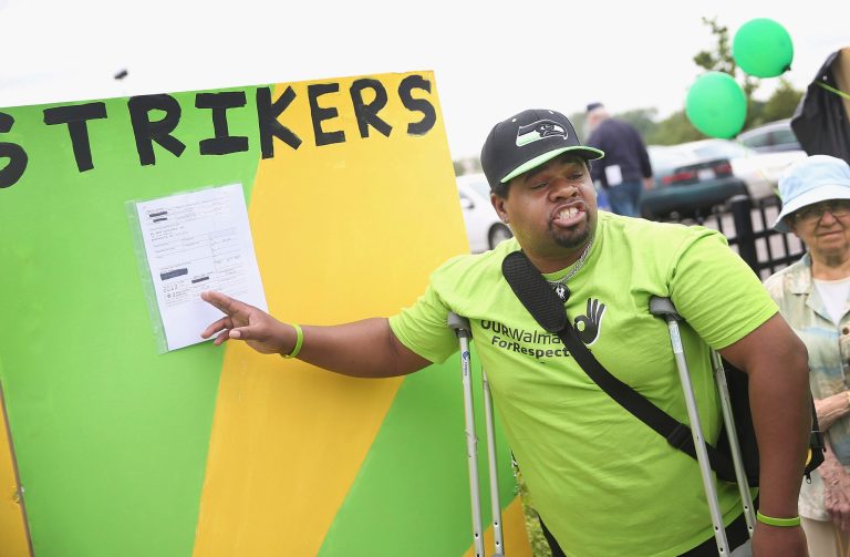 Myron Byrd puts his W-2 tax form on display during a protest outside a Wal-Mart store on June 4, 2014 in Chicago, Illinois. (Photo by Scott Olson/Getty Images)