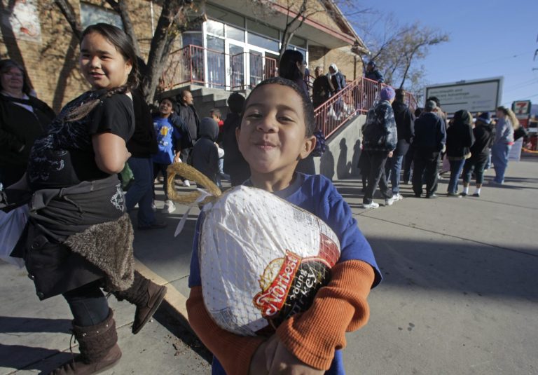 David Ikakoula, 5, carries his turkey at the Indian Walk-In Center Wednesday, Nov. 21, 2012, in Salt Lake City. (AP Photo)