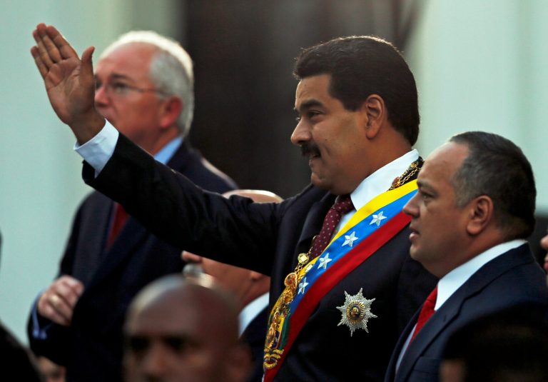 Flanked by Oil Minister Rafael Ramirez, left, and National Assembly's President Diosdado Cabello, Venezuelan President Nicolas Maduro greets supporters upon his arrival to the National Assembly for his annual state-of-the-nation address in Caracas, Venezuela, Wednesday, Jan. 15, 2014. (AP Photo/Fernando Llano)