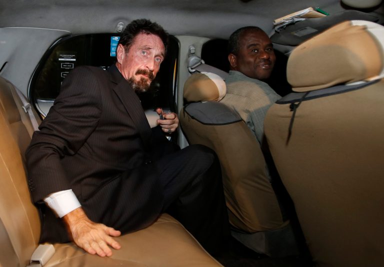   Anti-virus software founder John McAfee, left, sits in a taxi cab in the South Beach area of Miami Beach, Fla., on his way to dinner Wednesday, Dec 12, 2012. McAfee arrived in the U.S. on Wednesday night after being deported from Guatemala, where he had sought refuge to evade police questioning in the killing of a man in neighboring Belize. (AP Photo/Alan Diaz)  