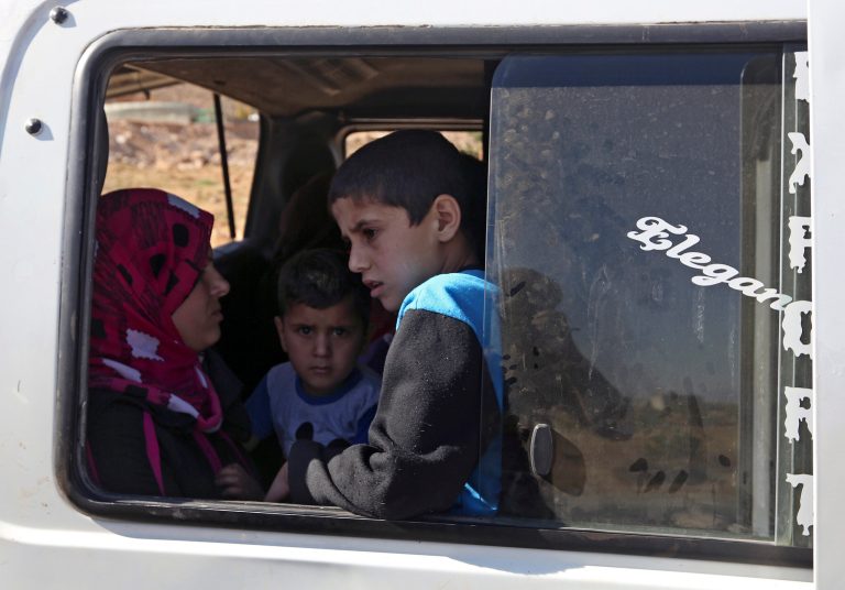 A Lebanese family wait to depart in a minibus on the outskirts of Arsal, a predominantly Sunni Muslim town near the Syrian border in eastern Lebanon, Monday, Aug. 4, 2014. Thousands of Lebanese civilians and Syrian refugees packed cars and pickup trucks Monday, fleeing an eastern border town that was overrun by militants from neighboring Syria as Lebanese troops fight to liberate the area. (AP Photo/Bilal Hussein)