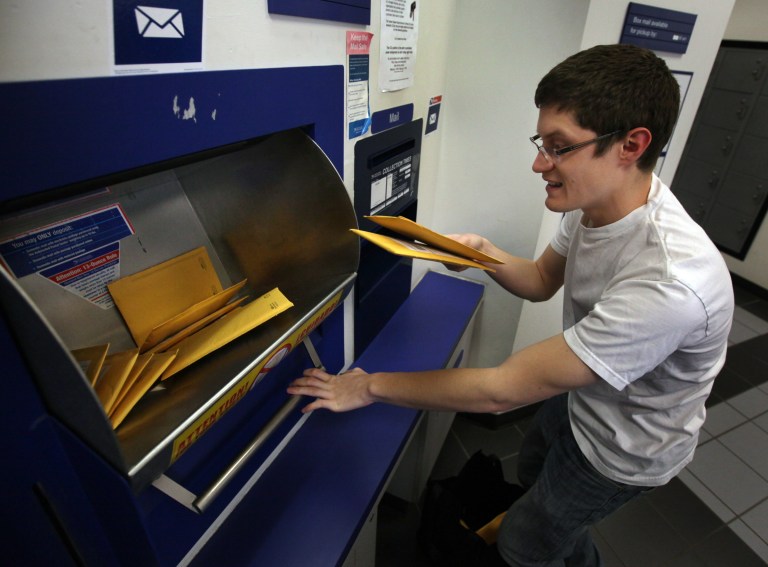 In this April 21, 2014 photo, Cell Focus owner Thomas Larson mails orders for a magnification lens that can be attached to a cellphone and turns it into a microscope, in Olympia, Wash. The Olympian reported that Larson raised nearly $112,000 through Kickstarter for his next product, a lens with 150 times magnification that he expects to produce this summer. (AP Photo/The Olympian, Steve Bloom)