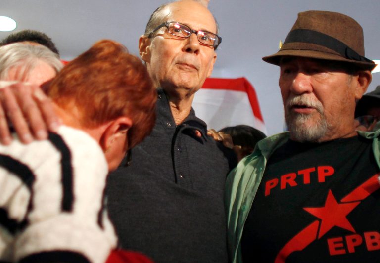   Avelino Gonzalez Claudio, center, is surrounded by supporters upon his arrival at the airport in San Juan, Puerto Rico, Thursday, Dec. 6, 2012. The former leader of a Puerto Rican militant group that has long fought for the island's independence arrived to finish serving a prison sentence for involvement in a $7 million robbery of a Wells Fargo armored depot in Connecticut in 1983. It was the biggest cash robbery in U.S. history at the time. (AP Photo/Ricardo Arduengo)  