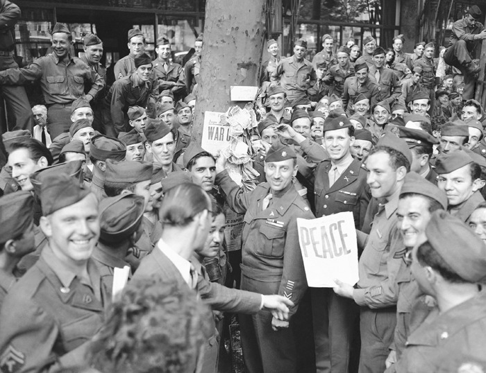 At the news of the Japanese acceptance of the Allied conditions, G.I.'s, go wild on Paris Boulevard, swarm over trucks, dance, wave flags of all nations, and cheer in France on August 23, 1945. (AP Photo/Henry Griffin)