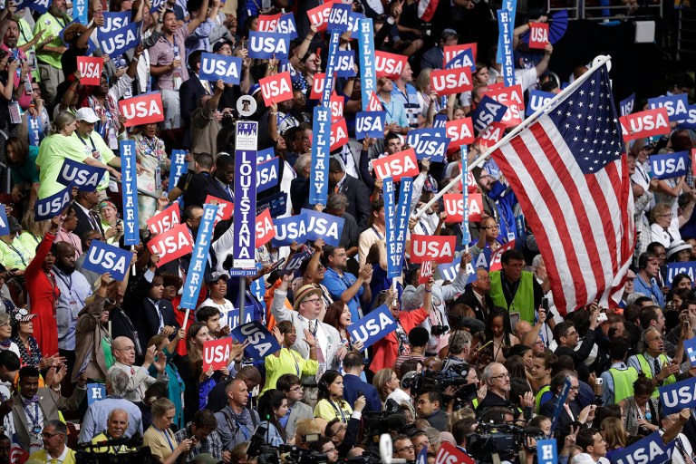 Convention officials distributed large American flags throughout the crowd for delegates to wave. (AP Photo/John Locher)