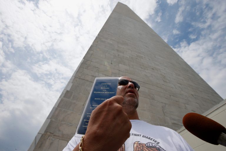 Marc Tanner, from Boca Raton, Fla., who was in the first group of tourists to visit the newly reopened Washington Monument, holds up a commemorative ticket to celebrate its re-opening, as he is interviewed by reporters after emerging from the monument, Monday, May 12, 2014, in Washington. The monument, which sustained damage from an earthquake in August 2011, reopened to the public today. (AP Photo)
