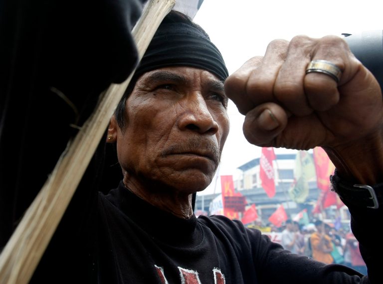   A protester clenches his fist during an anti-government rally near the Presidential Palace in Manila, Philippines Tuesday, June 12, 2012, to coincide with the 114th Declaration of Philippine Independence. The protesters criticized Aquino for allegedly acting slowly on implementing agrarian reforms. (AP Photo/Bullit Marquez)  