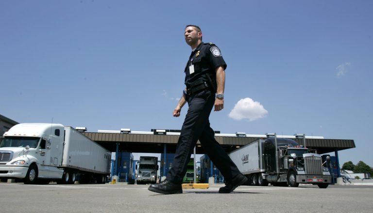 U.S. Customs and Border Protection officer Kevin Corsaro walks past a truck inspection station at the U.S. border in Buffalo, N.Y. (AP Photo/David Duprey)