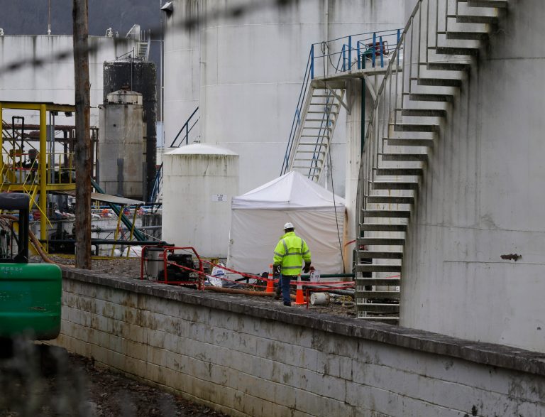 Work continues around storage tanks at Freedom Industries storage facility  in Charleston, W.Va..  The ban on tap water for parts of West Virginia was lifted on Monday, ending a crisis for a fraction of the 300,000 people who were told not to drink, wash or cook with water after a chemical spill tainted the water supply. (AP Photo/Steve Helber)