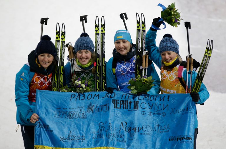 From left, Ukraine's relay team Vita Semerenko, Juliya Dzhyma, Olena Pidhrushna and Valj Semerenko pose with an Ukraine's flag, after winning the gold medal in the women's biathlon 4x6k relay at the 2014 Winter Olympics, Friday, Feb. 21, 2014, in Krasnaya Polyana, Russia. (AP Photo/Lee Jin-man)