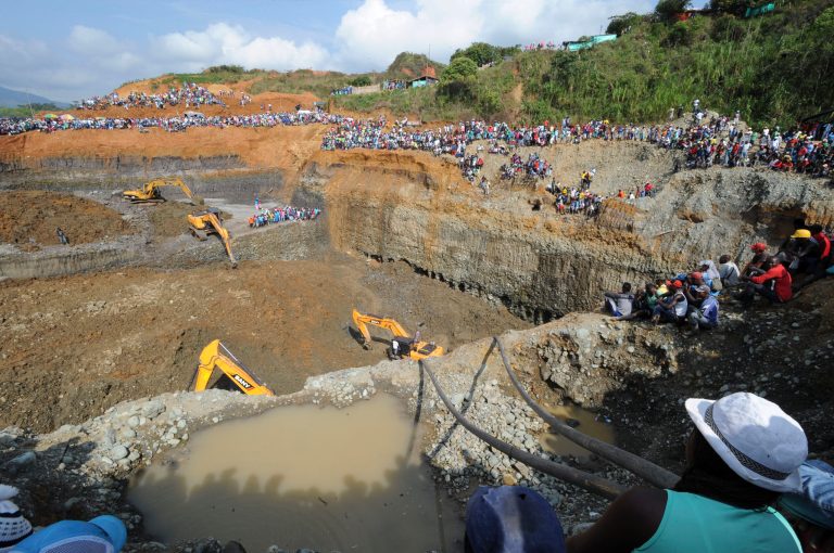 People watch machinery used to dig in search or survivors at a collapsed illegal gold mine in Santander de Quilichao, southern Colombia, Thursday, May 1, 2014. The bodies of three miners have been recovered and an unknown number remain missing, said Temistocles Ortega, governor of the Cauca state. (AP Photo/Oswaldo Paez, El Pais)