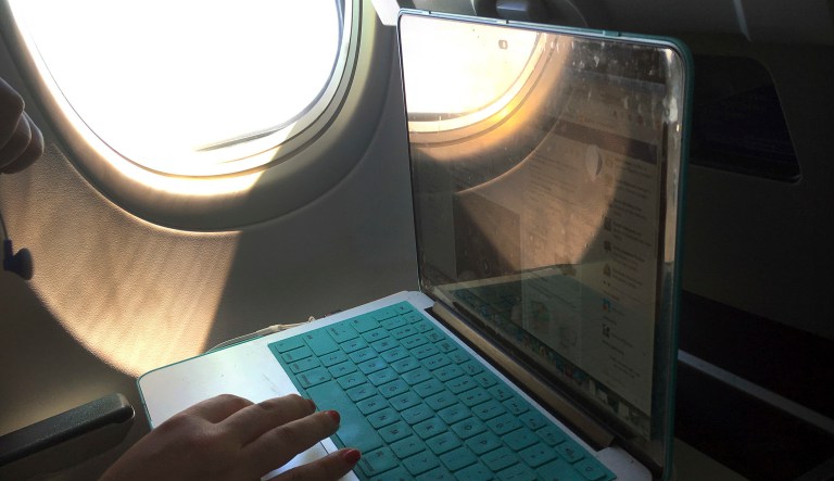 In this July 1, 2017, photo, a passenger uses a laptop aboard a commercial airline flight. (AP Photo/Bill Sikes)
