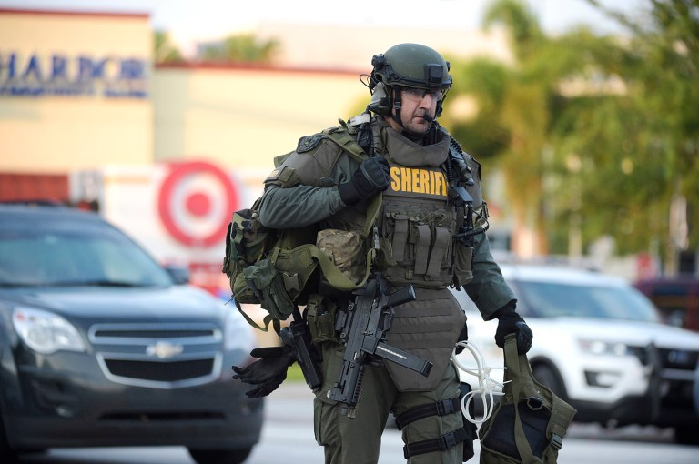 An Orange County Sheriff's Department SWAT member arrives to the scene of a fatal shooting at Pulse Orlando nightclub in Orlando, Fla., Sunday, June 12, 2016. (AP Photo/Phelan M. Ebenhack)