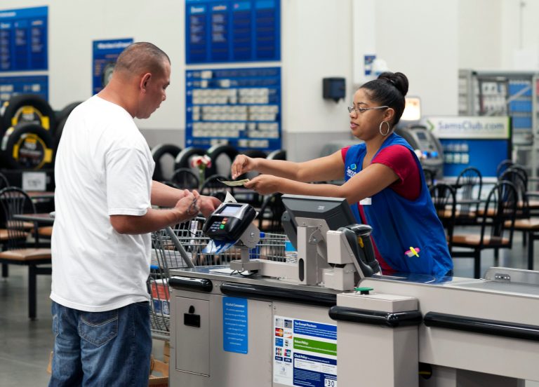 In this June 5, 2014 photo, Conquisia Tyler, right, gives change to a customer at Sam's Club in Bentonville, Ark. The Commerce Department releases personal income and spending for May on Thursday, June 26, 2014. (AP Photo/Sarah Bentham)