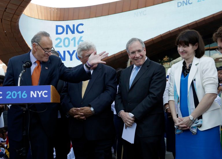 U.S. Sen. Charles Schumer, D-NY, left, introduces Democratic National Committee CEO Amy Dacey outside the Barclays Center, in the Brooklyn borough of New York,  Monday, Aug. 11, 2014. Schumer, Police Commissioner William Bratton and Barclays Center developer Bruce Ratner were among the political and business leaders who will welcome the Democratic National Committee to Brooklyn in a bid for the 2016 convention. New York City Comptroller Scott Stringer is second from right. (AP Photo/Richard Drew)