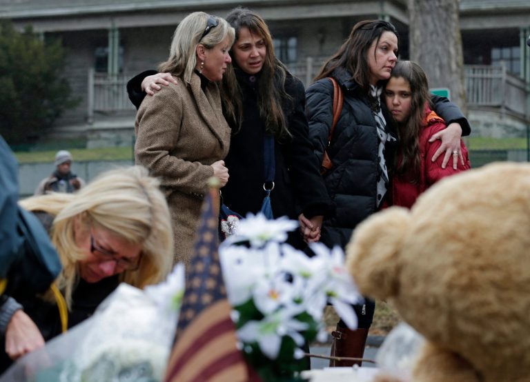 Women embrace at the site of a makeshift memorial for school shooting victims at the village of Sandy Hook in Newtown, Conn., in December 2012. (AP Photo/Charles Krupa)