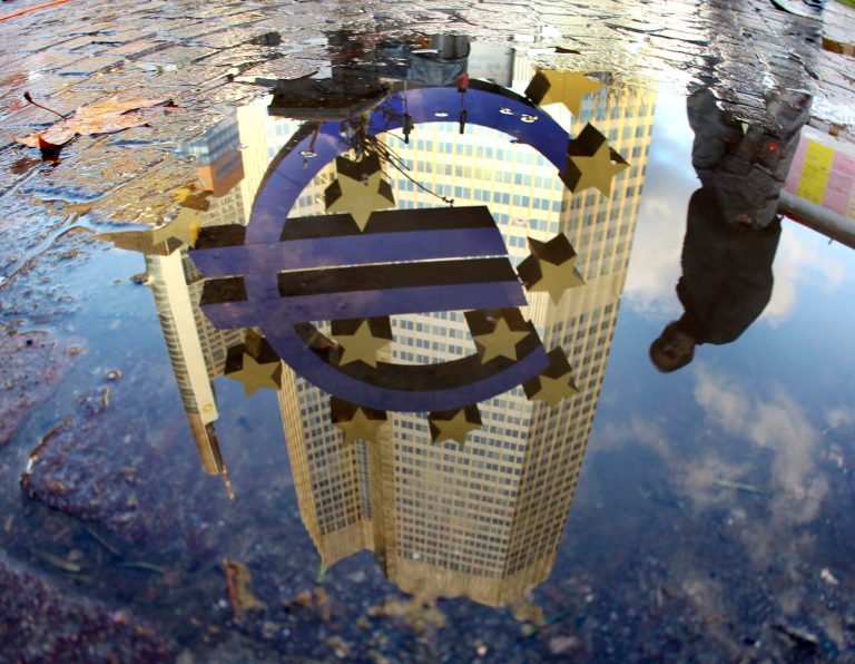 FILE - In this Thursday, Jan. 5, 2012 file photo, a person is reflected in a puddle alongside the Euro sculpture in front of the European Central Bank in Frankfurt, Germany. International investors are recovering their appetite for euros as the shared currency recovers from a debt crisis that threatened to break it up. (AP Photo/Michael Probst, File)