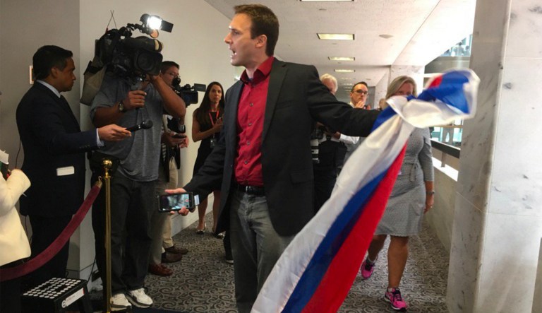 The protester asked Kushner to sign the flag, but he refused. (@MichaelMathes/Twitter)